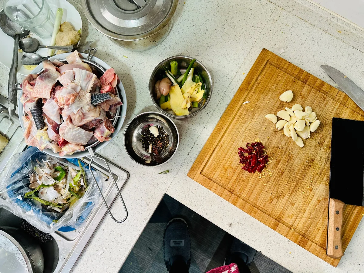 Three women exchanging labeled freezer lunches at a kitchen counter
